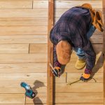 Caucasian Worker Building Wooden Deck For His Backyard Garden. Top View.