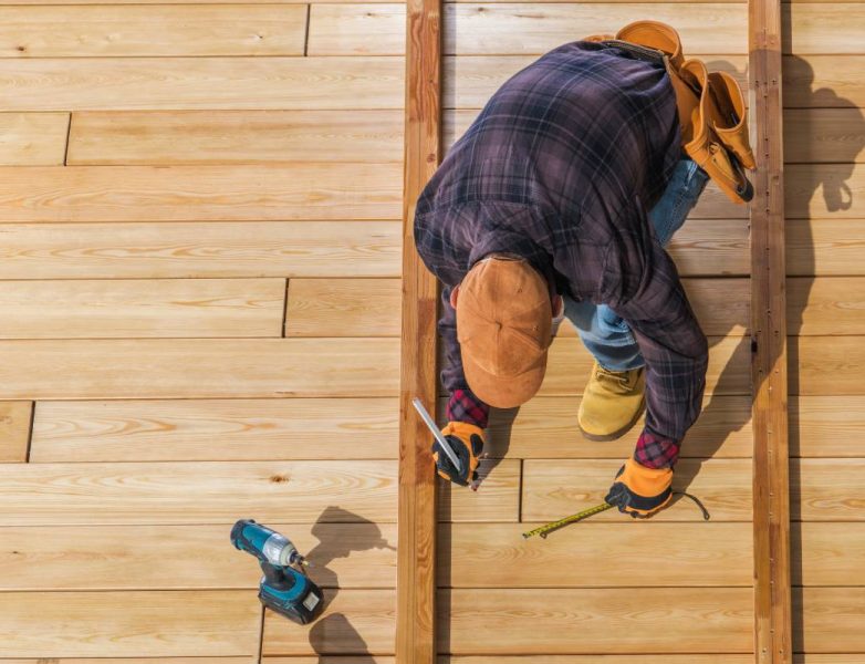 Caucasian Worker Building Wooden Deck For His Backyard Garden. Top View.