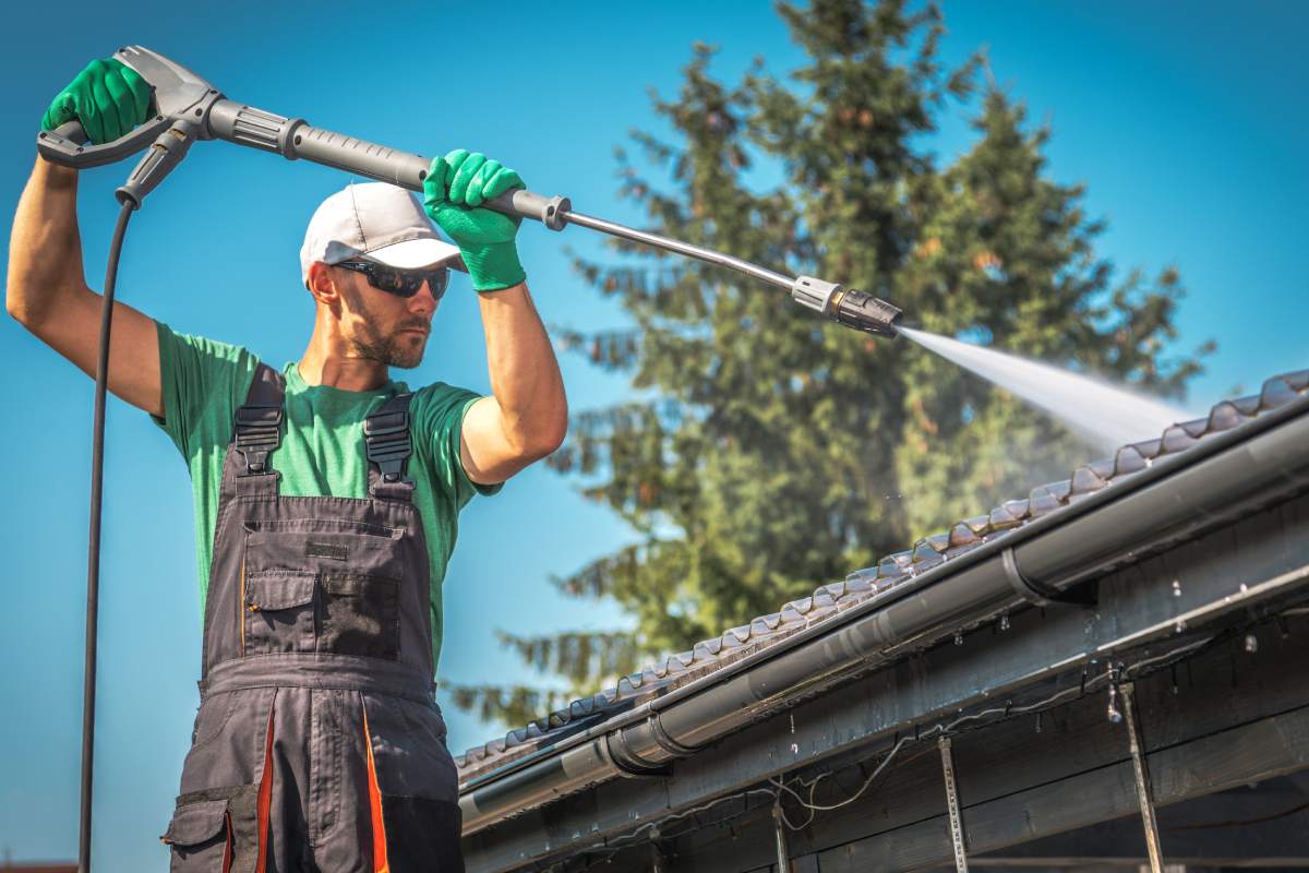 Washing Plastic Transparent Carport Roof by Caucasian Men. Pressure Washer gutter cleaning.